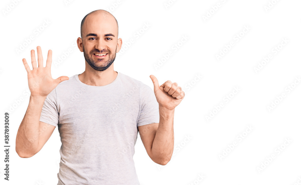 Young handsome man wearing casual t shirt showing and pointing up with fingers number six while smiling confident and happy. Young handsome man wearing casual t shirt showing and pointing up with fingers number six while smiling confident and happy.