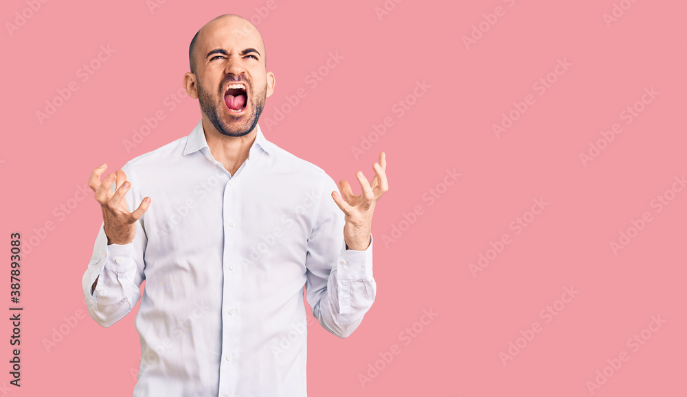 Young handsome man wearing elegant shirt crazy and mad shouting and yelling with aggressive expression and arms raised. frustration concept. Young handsome man wearing elegant shirt crazy and mad shouting and yelling with aggressive expression and arms raised. frustration concept.