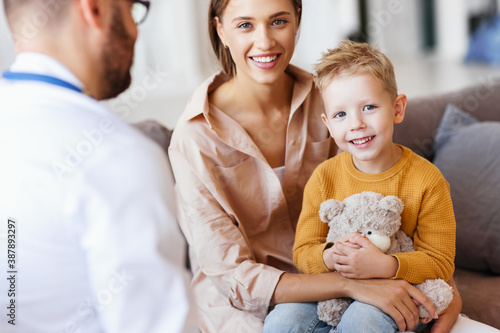 happy child boy patient with his mother at reception of a friendly pediatrician family doctor family pediatrician photo