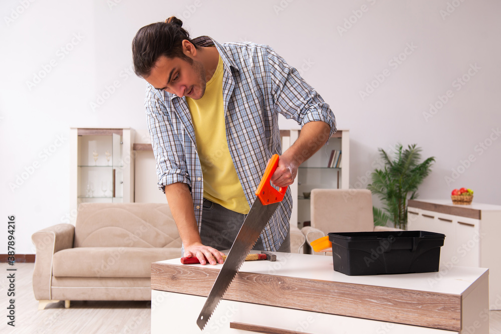 Young male carpenter repairing furniture at home Young male carpenter repairing furniture at home