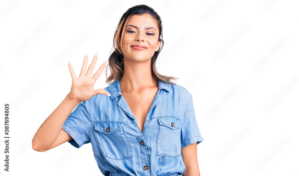 Young beautiful woman wearing casual clothes showing and pointing up with fingers number five while smiling confident and happy. Young beautiful woman wearing casual clothes showing and pointing up with fingers number five while smiling confident and happy.