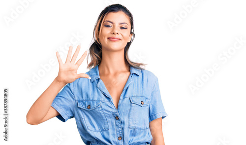 Young beautiful woman wearing casual clothes showing and pointing up with fingers number five while smiling confident and happy.