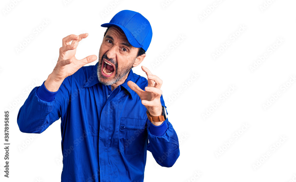 Middle age handsome man wearing mechanic uniform shouting frustrated with rage, hands trying to strangle, yelling mad Middle age handsome man wearing mechanic uniform shouting frustrated with rage, hands trying to strangle, yelling mad