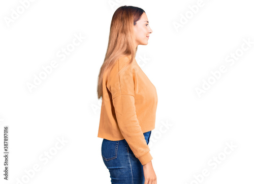 Beautiful young woman wearing casual clothes looking to side, relax profile pose with natural face with confident smile.