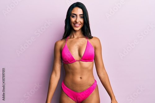Beautiful hispanic woman wearing bikini looking positive and happy standing and smiling with a confident smile showing teeth © Krakenimages.com
