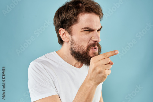Man with disgruntled facial expression gesturing with hands studio lifestyle blue background
