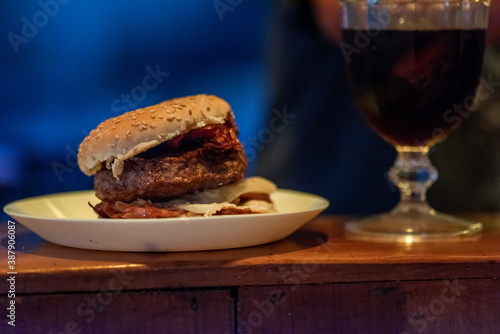 Juicy burger with a cup of win with a blurred fire background  