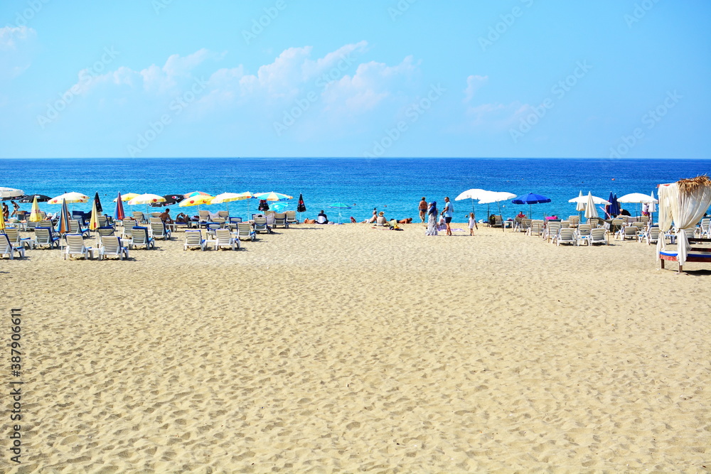 Coast of the Mediterranean sea, Turkey, Alanya. Wide sandy path to Cleopatra beach with sun umbrellas and sun beds without people. Recreation, swimming, sunbathing at the resort Coast of the Mediterranean sea, Turkey, Alanya. Wide sandy path to Cleopatra beach with sun umbrellas and sun beds without people. Recreation, swimming, sunbathing at the resort