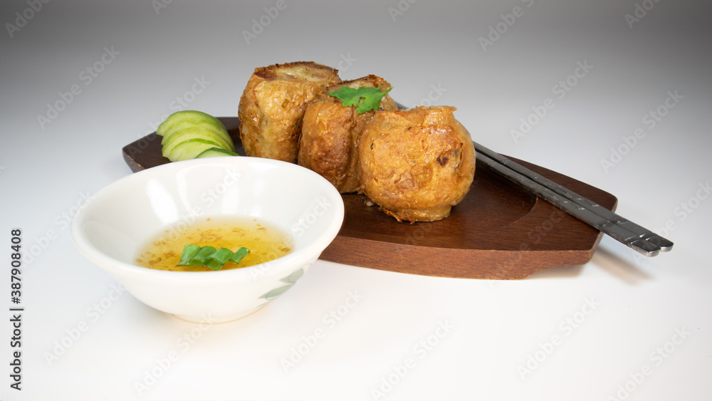 Hoi jo, Deep Fried Crab Meat Rolls, chinese traditional food on the wooden plate, serve with side dishes cucumber & plum sauce. Hoi jo, Deep Fried Crab Meat Rolls, chinese traditional food on the wooden plate, serve with side dishes cucumber & plum sauce.