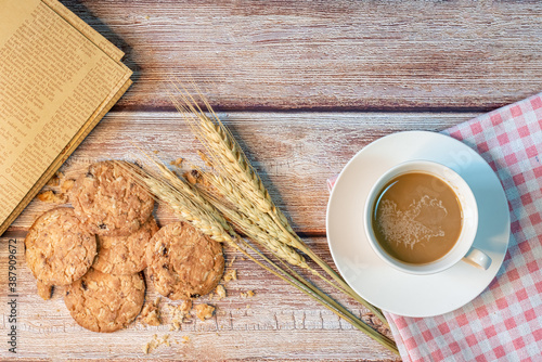 Coffee in a white cup and oatmeal cookies.