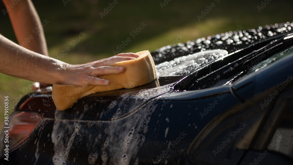 close up of a men wahing a car