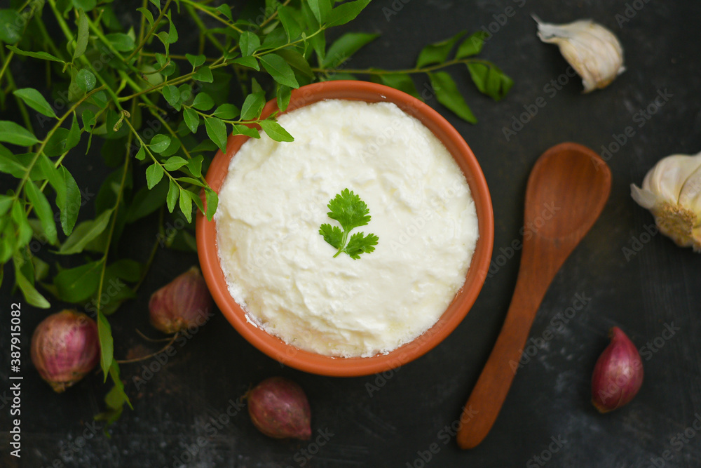 Bowl of homemade sour cream curd yogurt Dahi fresh herbs curry leaf