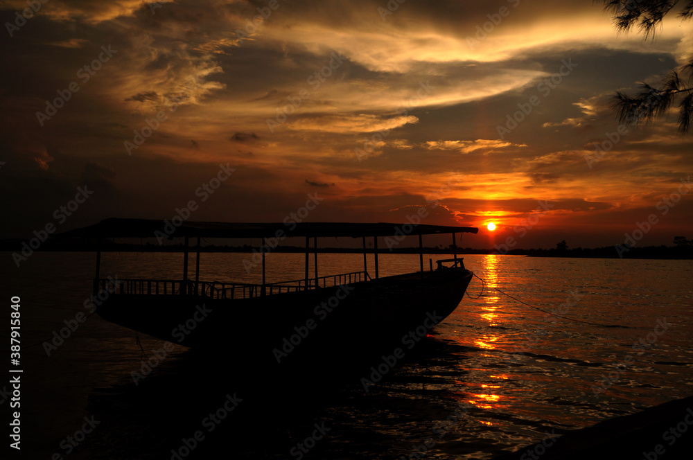 Obraz premium Silhouette of ship on the beach at sunset