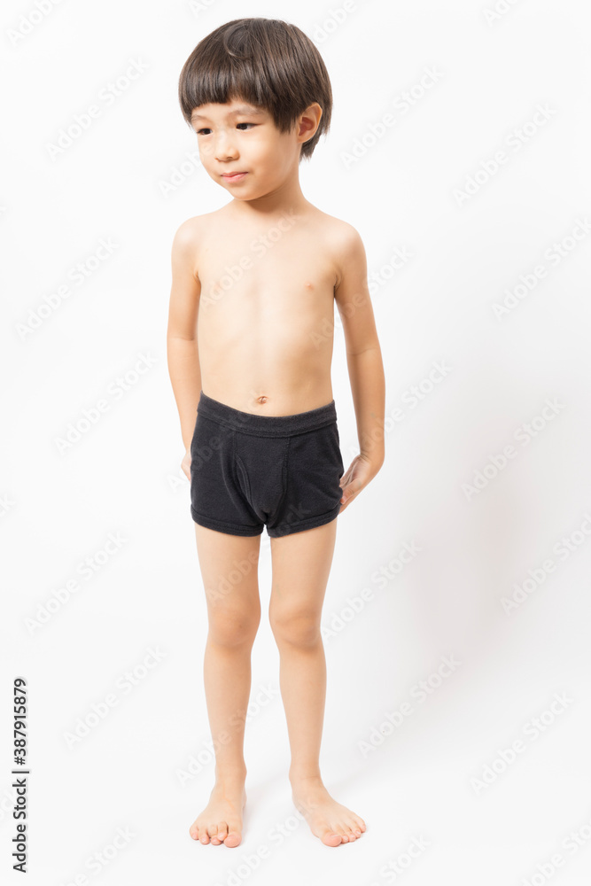 Cute little Asian 3 years old toddler boy wearing black shorts standing on white background. Cute little Asian 3 years old toddler boy wearing black shorts standing on white background.
