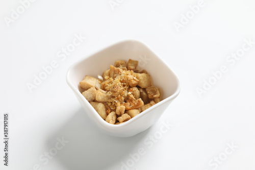 Delicious fat food, fried greaves pork in a bowl on white background.
