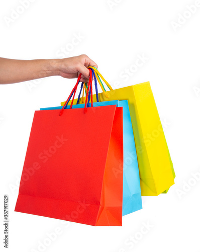 Hand holding multicolored paper bags isolated on white