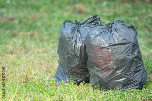 two black garbage bags put on grass floor