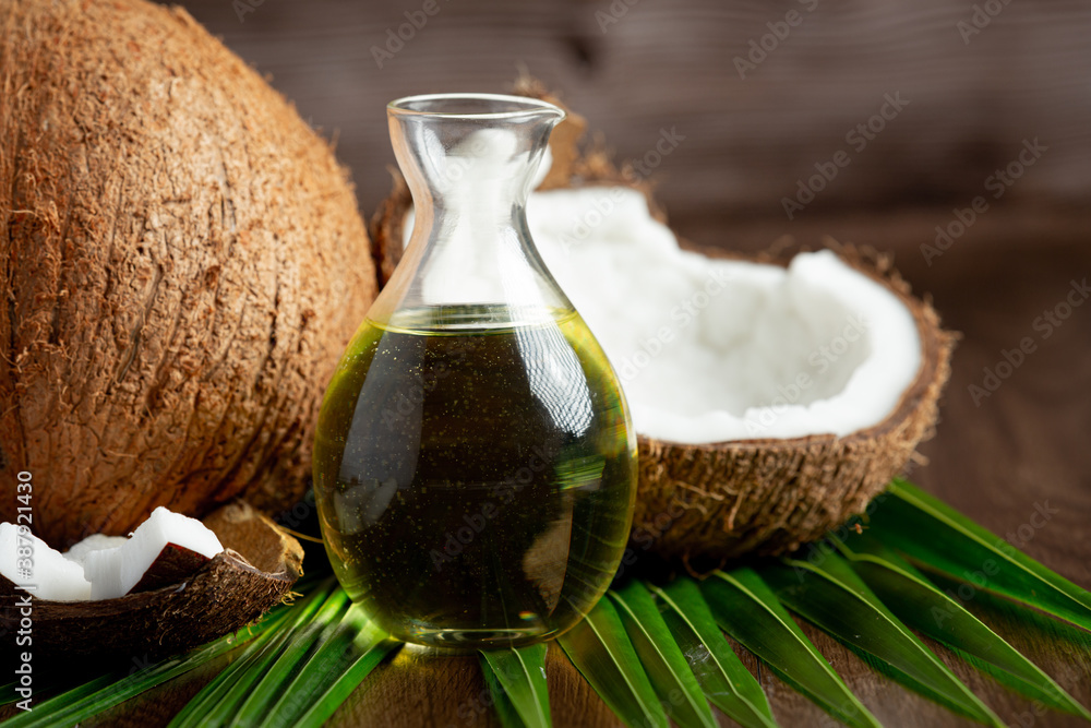 a jug of coconut oil whit coconut put on dark background a jug of coconut oil whit coconut put on dark background