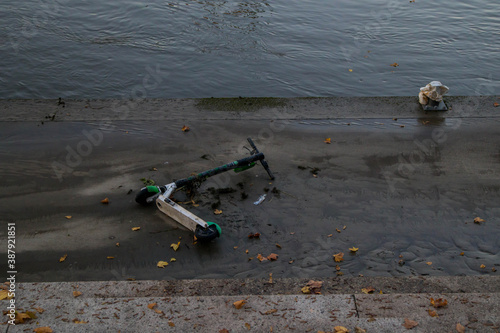 Wroclaw, Poland, October 24, 2020. Electric scooter left on an embarkment that was flooded by Oder River