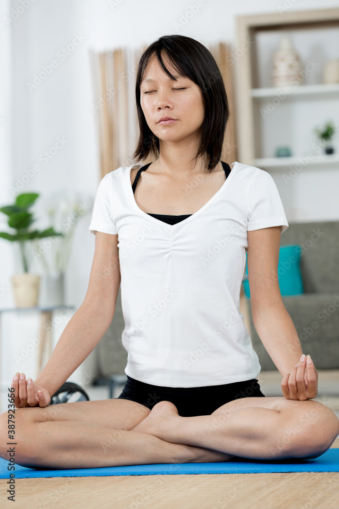 young woman practicing yoga in lotus pose