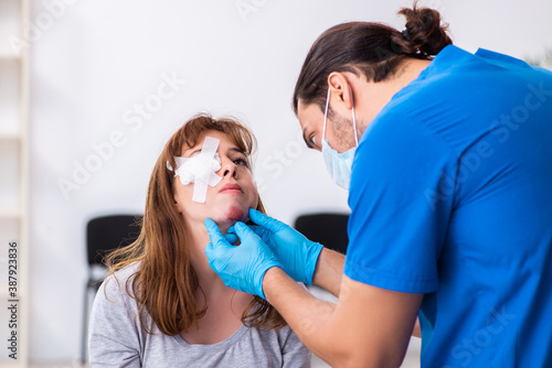 Young head injured woman visiting young male doctor