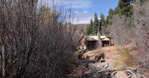 Mountain scenic valley log cabin along river 4K. Beautiful autumn fall colors along Wasatch Mountains. Valley landscape with road and colorful fall trees. Rural farming community. photo