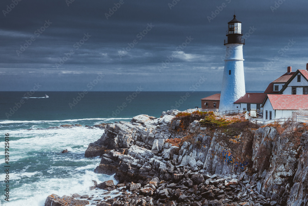 Lighthouse in South Maine with White Water Ocean and Dark Skies