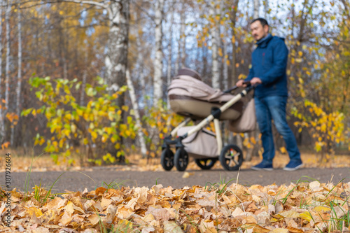 A man with a pram in the autumn Park. Selective focus