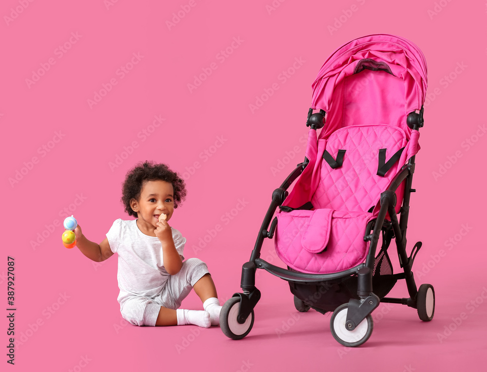Cute African-American baby and stroller on color background Cute African-American baby and stroller on color background