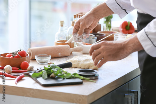 Mature chef cooking in kitchen, closeup