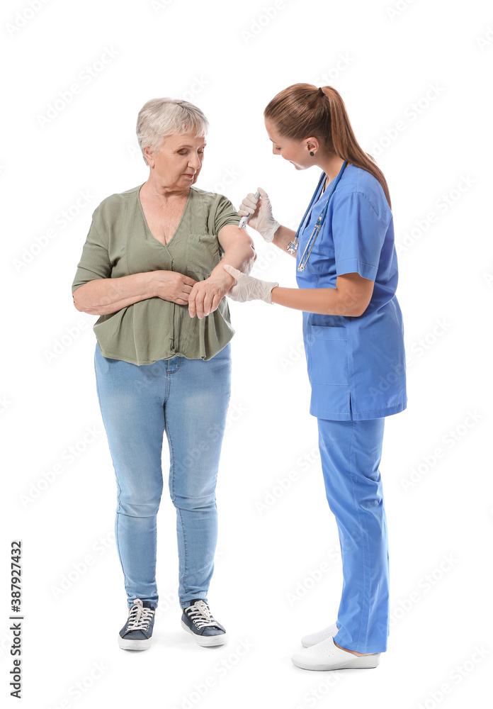 Doctor giving senior diabetic woman insulin injection on white background Doctor giving senior diabetic woman insulin injection on white background