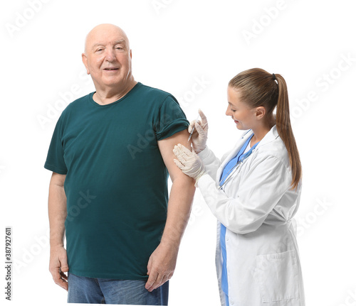 Doctor giving senior diabetic man insulin injection on white background