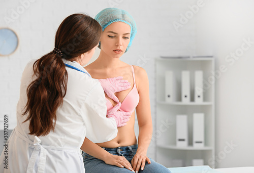Fotografi Mammologist examining young woman in clinic
