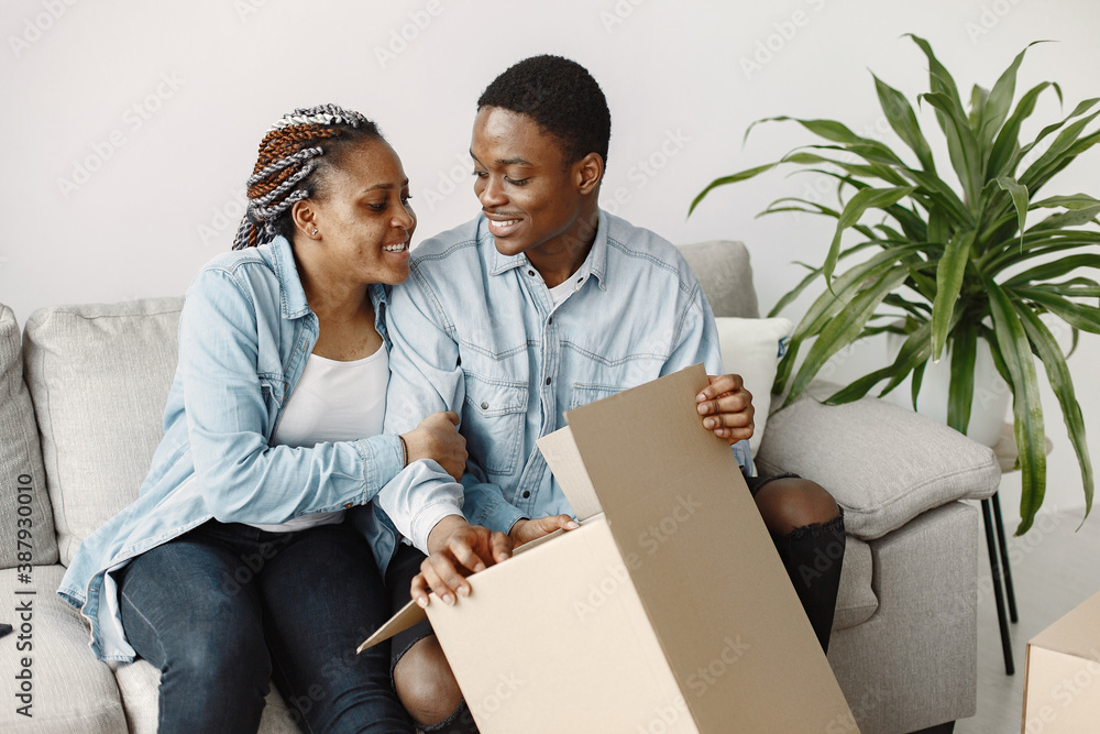 Young couple moving in to new home together. African american couple with cardboard boxes. Young couple moving in to new home together. African american couple with cardboard boxes.