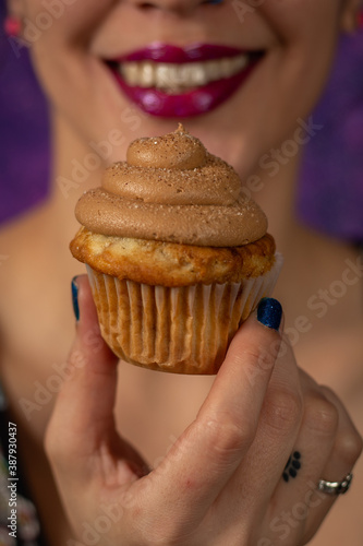 Tattooed model holding a cupcake 