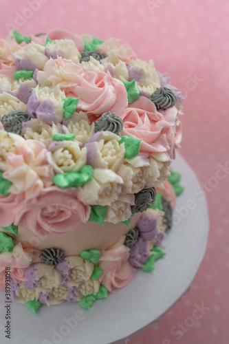 Floral frosted layer cake on pink background