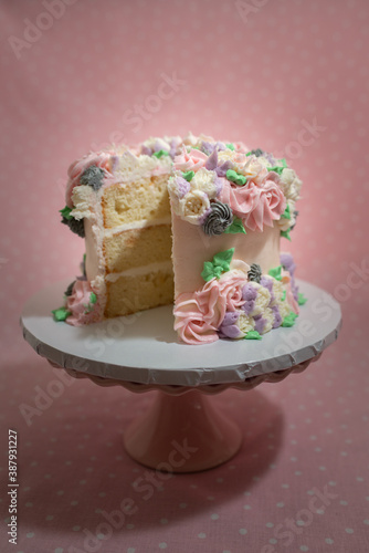Floral frosted layer cake on pink background
