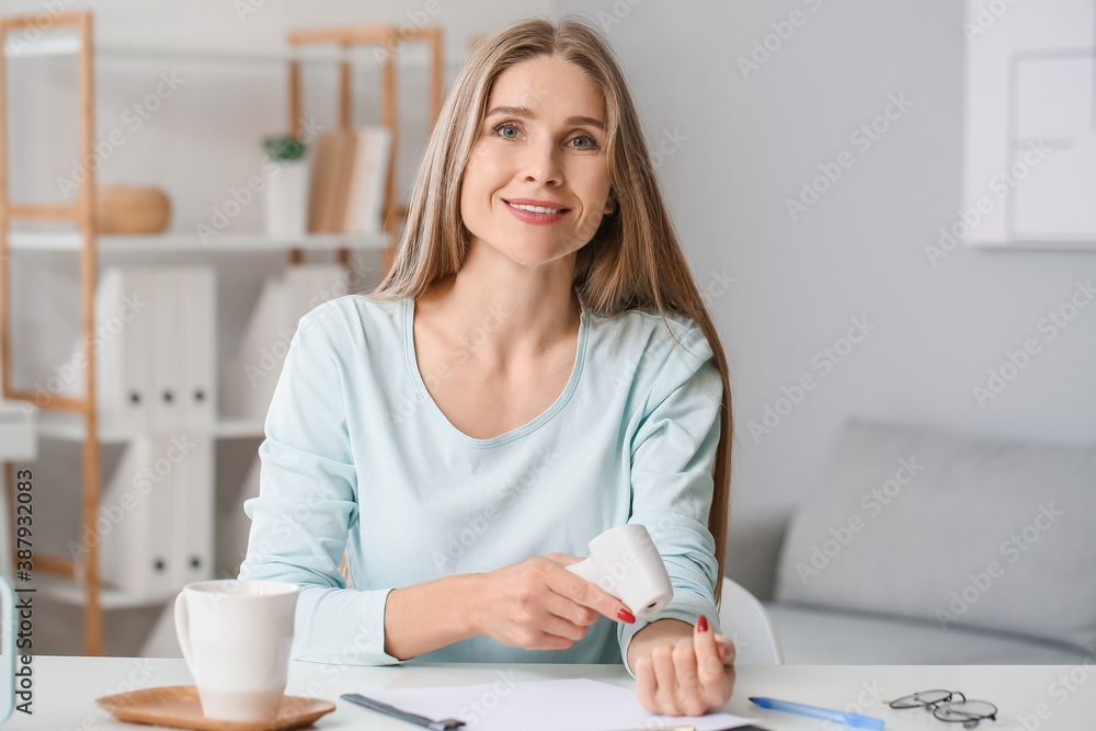 Woman with infrared thermometer measuring temperature in office. Coronavirus epidemic Woman with infrared thermometer measuring temperature in office. Coronavirus epidemic
