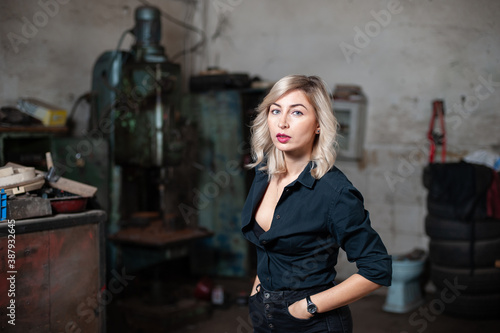 Portrait of a beautiful young blonde woman with blue eyes with old machinery  © xpabli