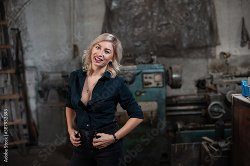 Portrait of a beautiful young blonde woman with blue eyes with old machinery 