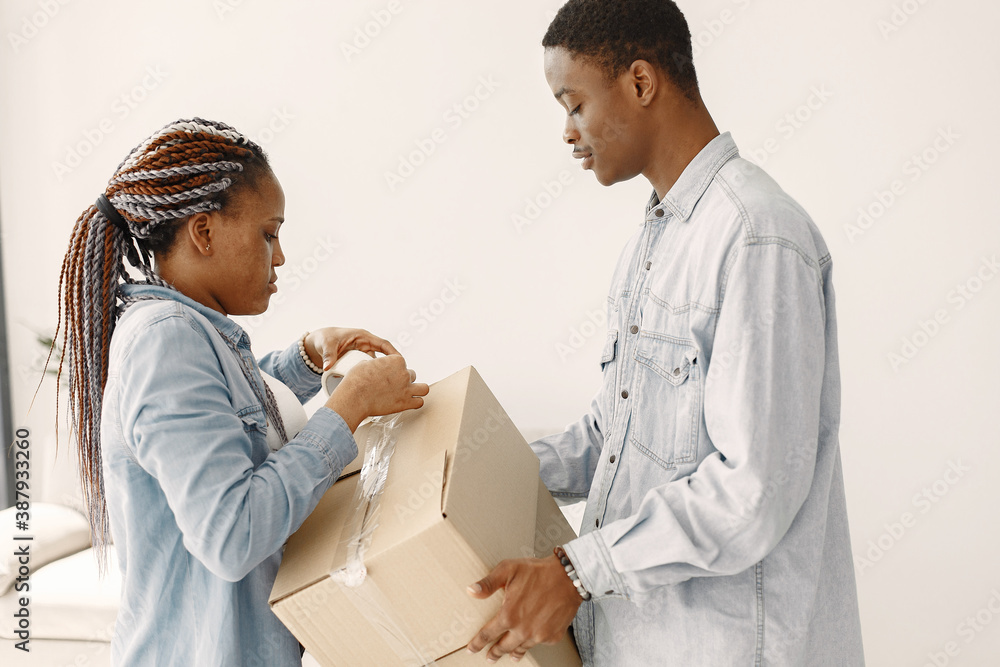 Young couple moving in to new home together. African american couple with cardboard boxes. Young couple moving in to new home together. African american couple with cardboard boxes.