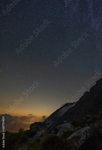 Sternenhimmel in den Alpen mit Wolken und Abendrot 
