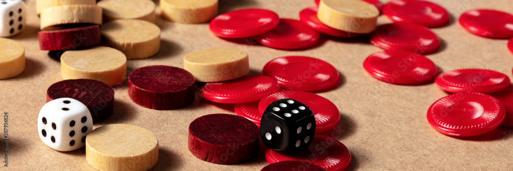 Board games panorama with various pieces and dice on a brown background Board games panorama with various pieces and dice on a brown background