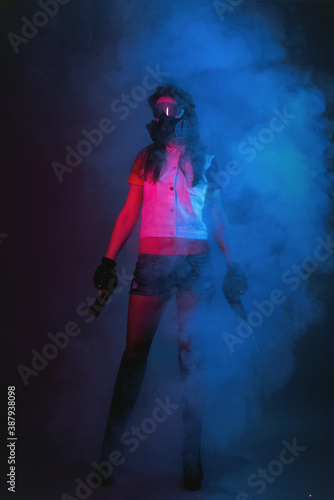 Girl with a toy guns in hands in the smoke. Cyberpunk concept.