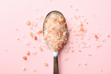 Spoon with pink himalayan salt on pink background