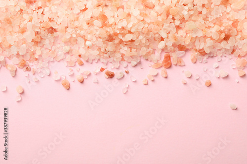 Pink himalayan salt on pink background, space for text