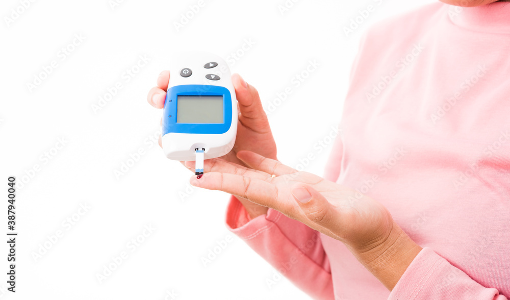 Closeup hands woman measur glucose test level check with blood on finger by glucometer she monitor and control high blood sugar diabetes and glycemic health care concept isolated on white background Closeup hands woman measur glucose test level check with blood on finger by glucometer she monitor and control high blood sugar diabetes and glycemic health care concept isolated on white background