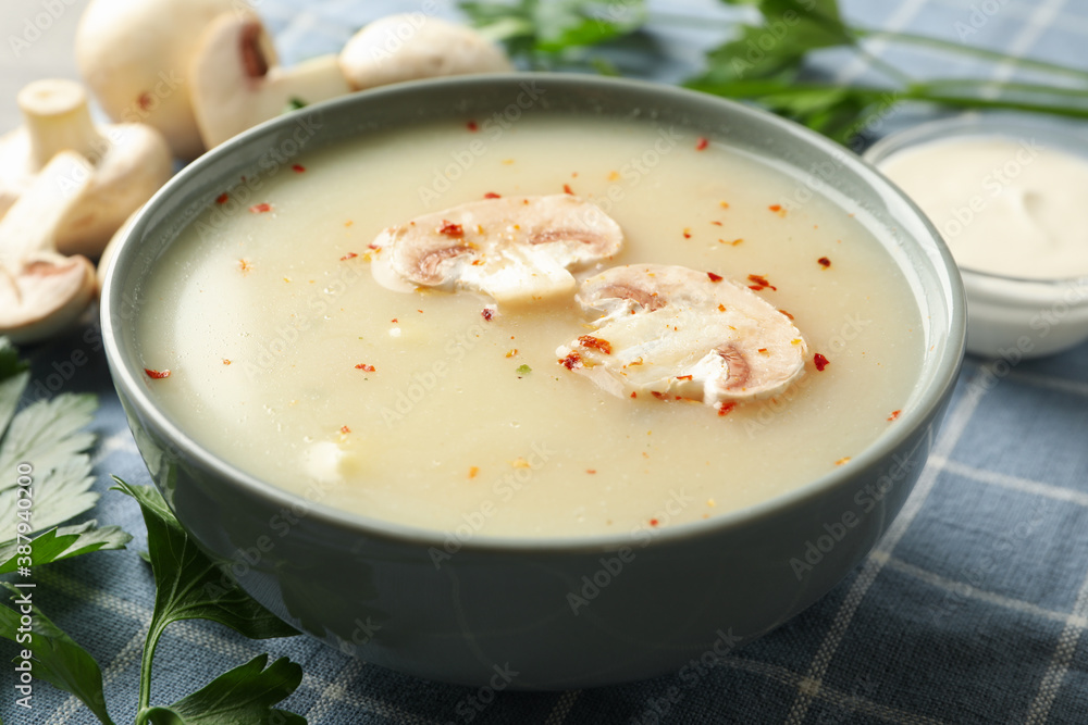 Concept of tasty lunch with bowl of mushroom soup on napkin background Concept of tasty lunch with bowl of mushroom soup on napkin background
