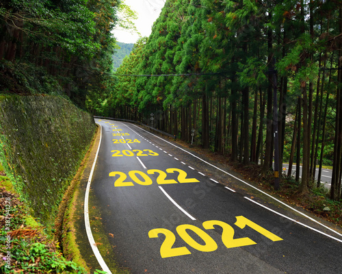 Ten year from 2021 to 2030 on highway road and white marking lines in the forest, Happy new year and road to success concept