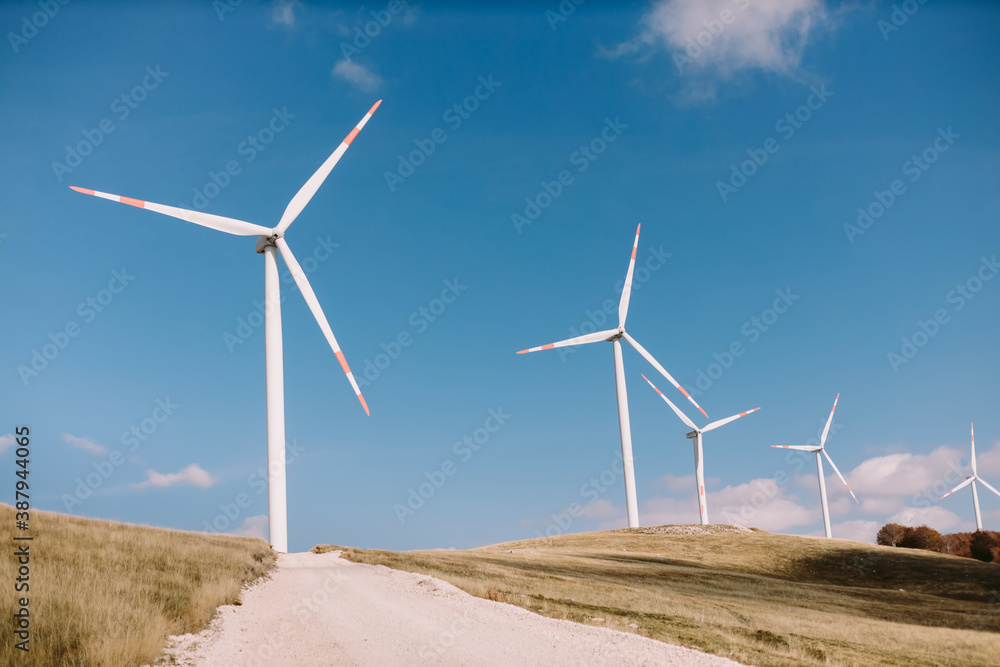 wind turbine farm. Wind power station with a group of wind turbines onshore in a beautiful scenery. 